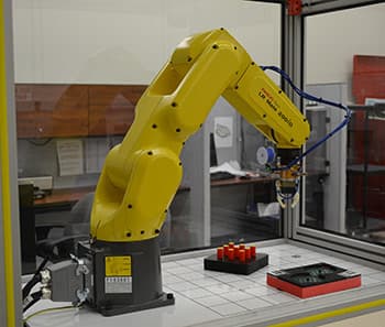 Industrial robot arm demonstrating dexterity on NIST test artifacts