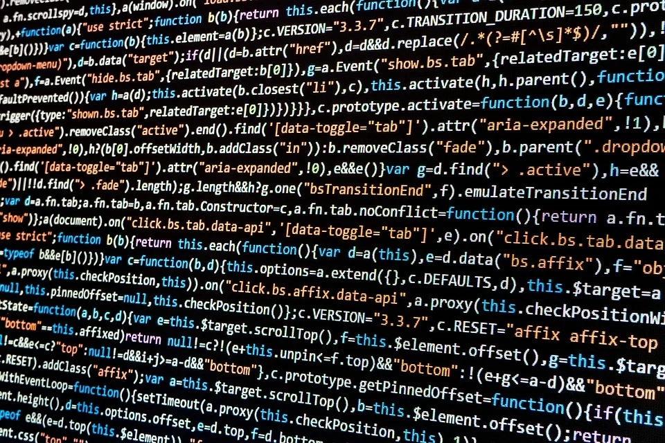 Close-up of programming code in white, orange and blue text on a dark computer screen.
