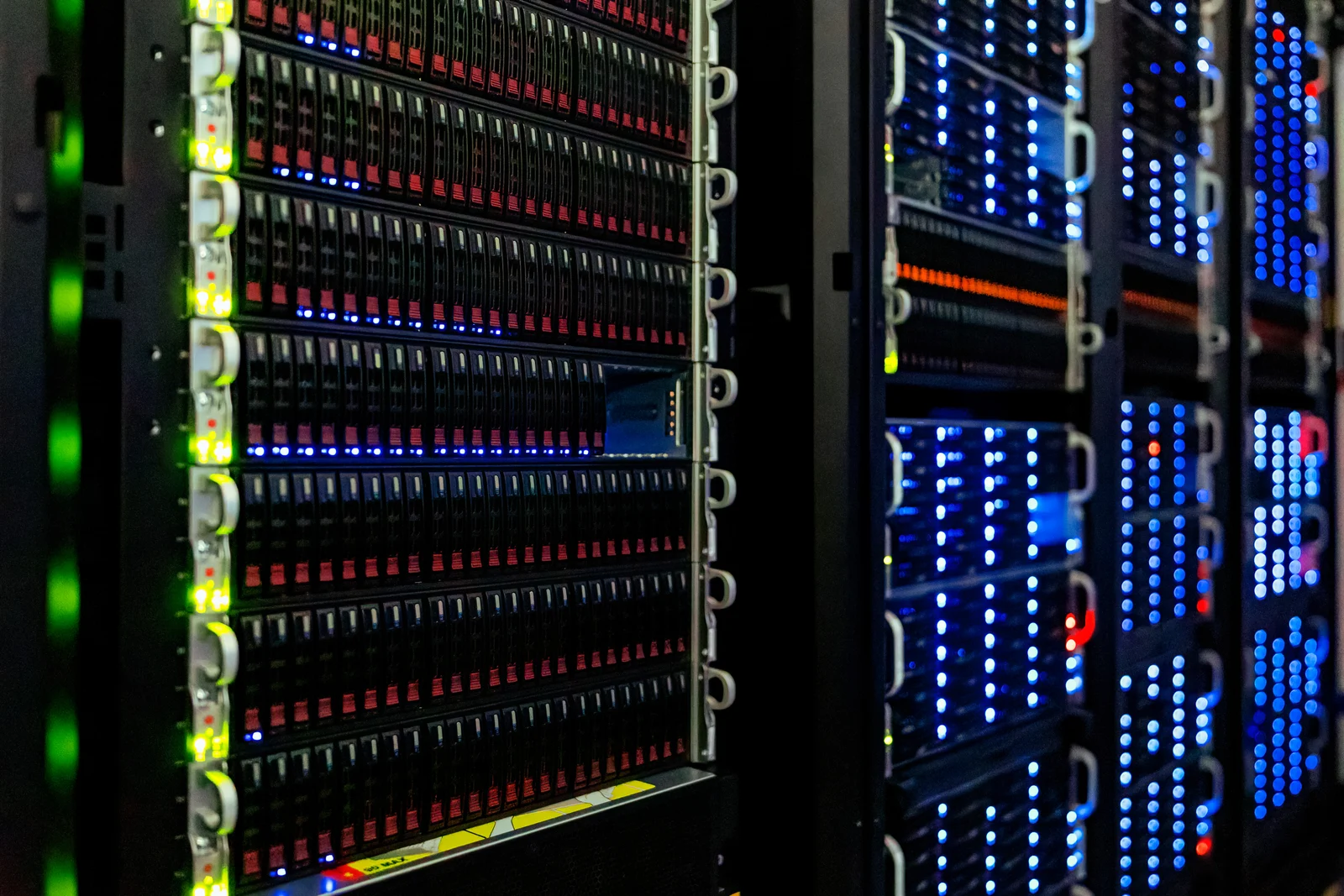 Dark server racks containing rows of drive bays and blue, green and red status lights.
