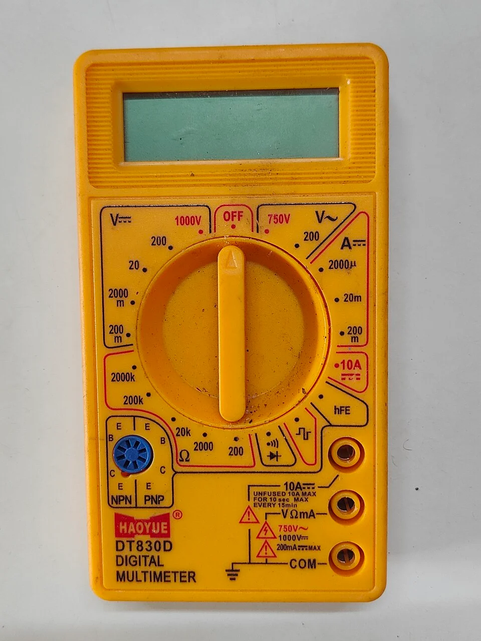 A DT830D digital multimeter used to measure electrical quantities.