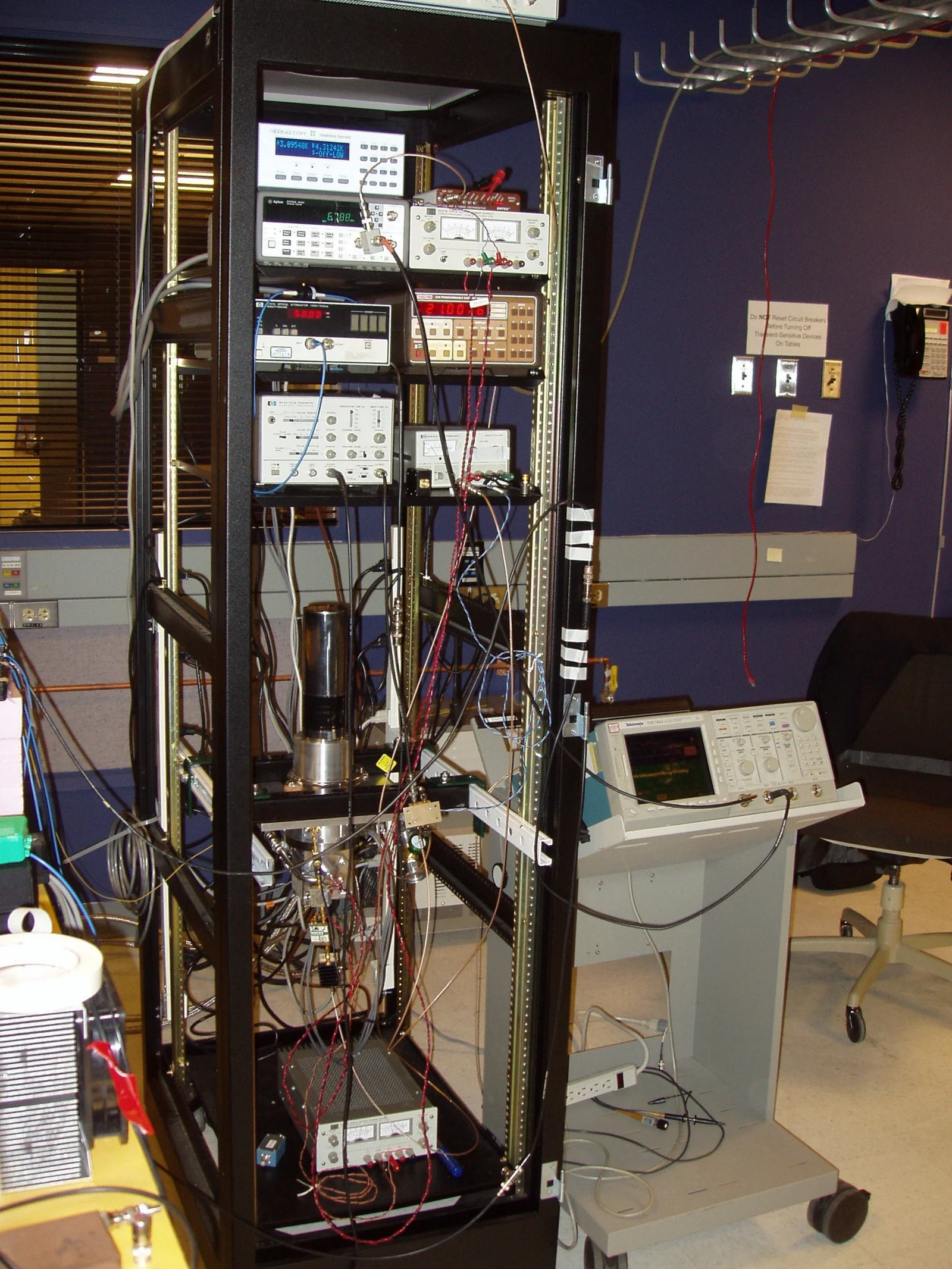 A tall equipment rack with instruments, cables and a superconducting nanowire single-photon detector installed for the historical DARPA Quantum Network.