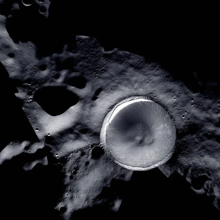 Mosaic image of Shackleton Crater near the lunar South Pole, combining data from NASA's Lunar Reconnaissance Orbiter and ShadowCam, with shadowed crater interior and lit rim.