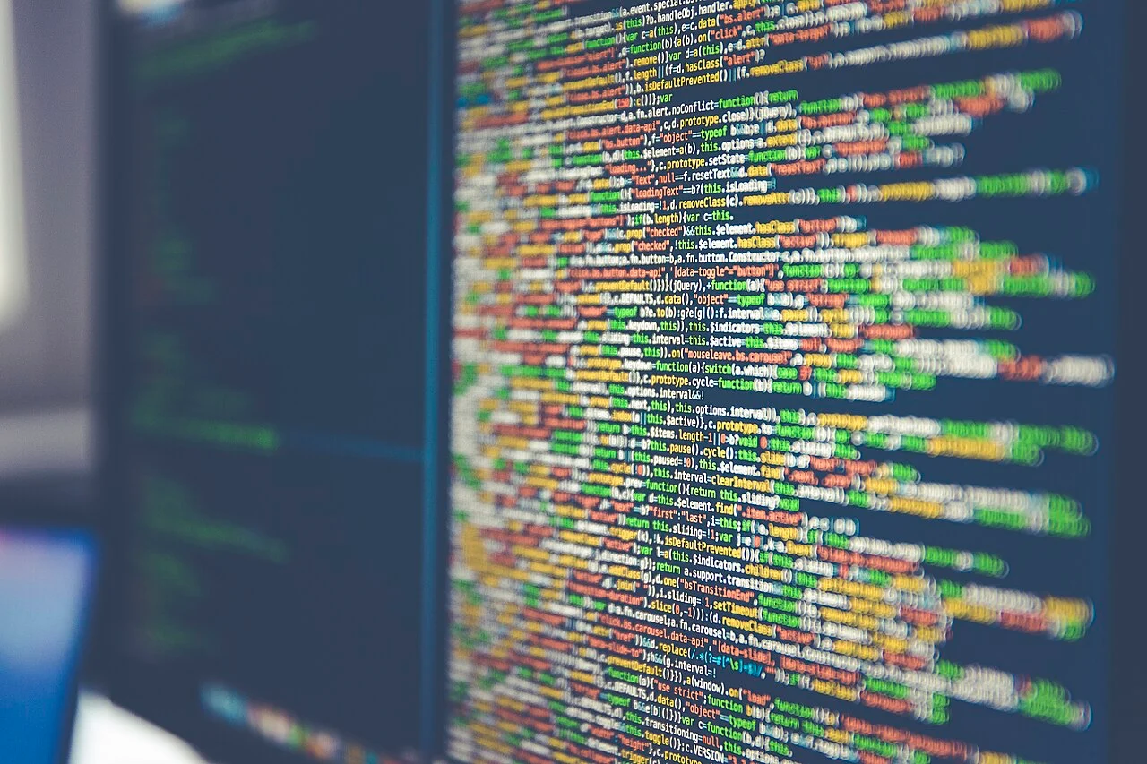 Shallow-focus close-up of multicolored JavaScript source code displayed on a computer monitor.